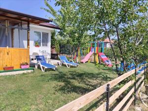 a yard with a playground with chairs and a house at Къща Виктория in Banya