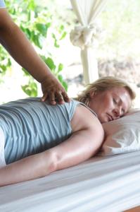 a woman laying on a bed with her hand on a pillow at Koh Talu Island Resort in Bang Saphan Noi