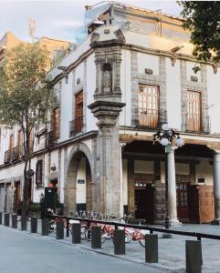 a building with a statue in front of it at Domingo Santo Hotel Boutique in Mexico City