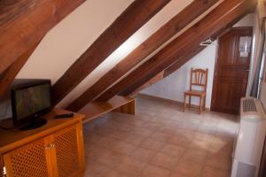 an attic room with a tv and a chair at Hostal Mar de Frente in Los Caños de Meca