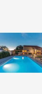 a large blue swimming pool sitting on top of a house at Villa Marina in Biograd na Moru