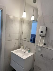 a white bathroom with a sink and a mirror at Luxury central apartments in Pisa +31 photos