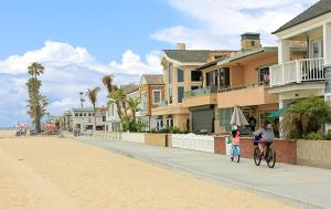 a woman and a child riding a bike down a street at 1404 W Oceanfront C in Newport Beach
