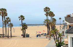 a sandy beach with palm trees and a pier at 1404 W Oceanfront C in Newport Beach