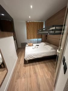 a bedroom with a bunk bed and wooden floors at KYRIAD ECO LILLE SUD - Noyelles Godault in Noyelles-Godault