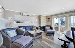 a living room with a blue couch and chairs at 2314 W Oceanfront A & B in Newport Beach