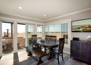 a dining room with a table and chairs and windows at 2314 W Oceanfront A & B in Newport Beach +38 photos