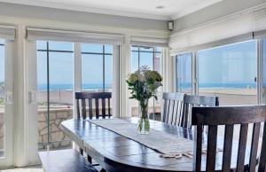 a dining room with a table with a vase of flowers at 2314 W Oceanfront A & B in Newport Beach