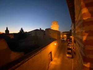 a view of a city at night with a clock tower at Sego Apartments I in Segovia