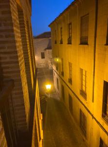 an empty street at night with a street light between two buildings at Sego Apartments I in Segovia +6 photos