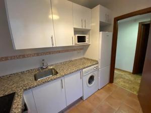 a kitchen with a sink and a white refrigerator at Sego Apartments I in Segovia