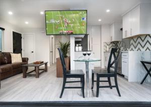 a kitchen and living room with a tv on the wall at 5 Bedrooms in Newport Beach