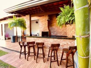 a group of stools on a patio with a bar at Casa Sa Pedra in Aparecida de Goiânia
