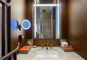 un bagno con un lavandino e un grande specchio di 西安曲江芳林苑酒店 a Xi'an Altre 37 foto