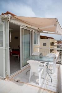 トロにあるOlga's Sea View Apartment by HSHのバルコニーにテーブルと椅子が置かれたパティオ