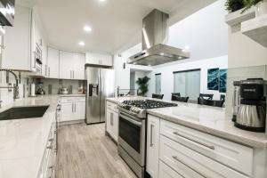 a kitchen with white cabinets and a stove top oven at 5 Bedrooms in Newport Beach +16 photos