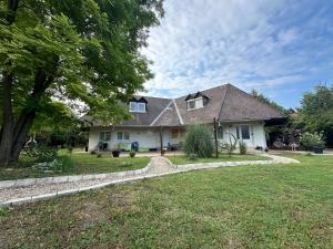 a house with a landscaped yard with a tree at Levendulakert Siófok Apartmanház in Siófok