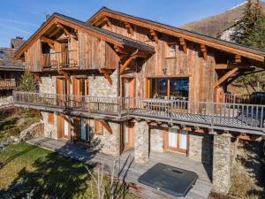 an exterior view of a log home with a deck at Chalet avec jacuzzi, proche des pistes, pour 10 personnes - FR-1-570-20 in Saint-Martin-de-Belleville