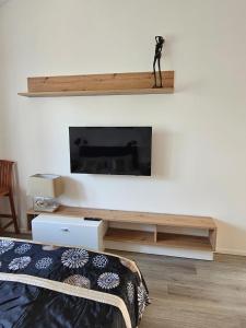 a living room with a tv and a bed at Vila DRAGONFLY in Šventoji