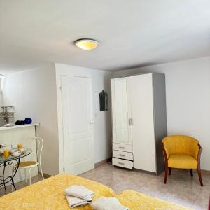 a bedroom with a bed and a table and a cabinet at Studio agréable en forêt in Saint-Jouan-des-Guérets