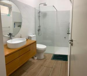 Un baño con lavabo, inodoro y ducha. en Flat Mindelo 30, en Mindelo 5 fotos más