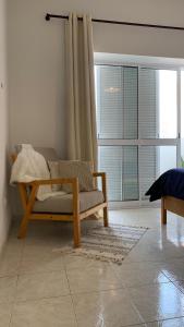 Una sala de estar con un sofá y una ventana grande. en Flat Mindelo 30, en Mindelo