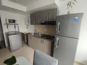 a kitchen with a stainless steel refrigerator and a microwave at Apartamento frente a la montaña en Armenia Quindio - 1 Dormitorio Piso 11 in Armenia