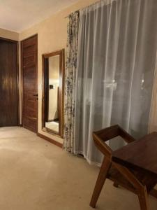 a room with a mirror and a chair in front of a window at Villa Natural en Chemuyil in Balcheil