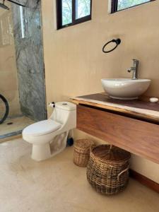 a bathroom with a toilet and a sink at Villa Natural en Chemuyil in Balcheil