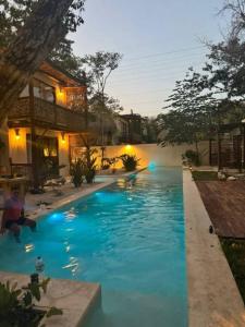 a blue swimming pool in front of a house at Villa Natural en Chemuyil in Balcheil