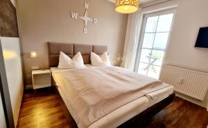 een slaapkamer met een groot bed met een groot raam bij Hafenidyll 46 in Ostseebad Karlshagen