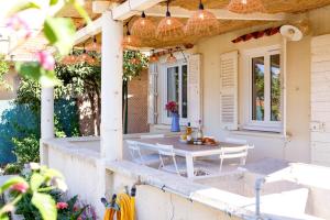 un patio con tavolo e sedie in una casa di Maisonnette vue mer au Pradet a Le Pradet