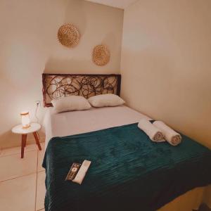 ein Schlafzimmer mit einem Bett mit einer grünen Bettdecke in der Unterkunft Pousada Mar de Sonhos in Maragogi