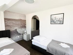 a bedroom with two beds and a painting on the wall at Sztorm Rowy in Rowy