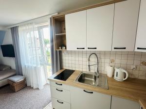 a kitchen with white cabinets and a sink at Sztorm Rowy in Rowy