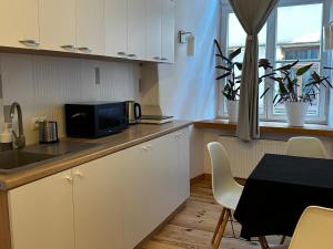 a kitchen with a microwave and a table with chairs at Rynek 5 Stara Winiarnia in Lublin +9 photos