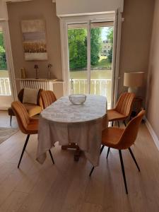 a dining room with a table and chairs and a couch at Villa Catherine in Olivet