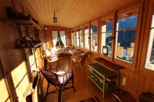 einen Blick über ein Zimmer mit Stühlen und Fenstern in der Unterkunft Fauvettes in Chateau-d'Oex