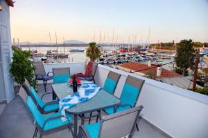 a balcony with tables and chairs and a marina at Aroura Maisonette Spetses 4BR in Spetses