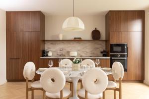 Appartement Luxueux - 2BR 6P -Vue Tour Eiffel في باريس: مطبخ وغرفة طعام مع طاولة وكراسي