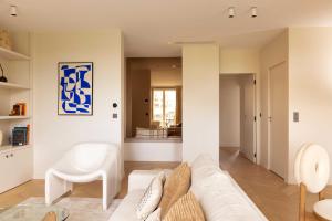 a living room with a white couch and a table at Appartement Luxueux - 2BR 6P -Vue Tour Eiffel in Paris +13 photos