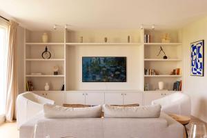 a living room with a white couch and shelves at Appartement Luxueux - 2BR 6P -Vue Tour Eiffel in Paris