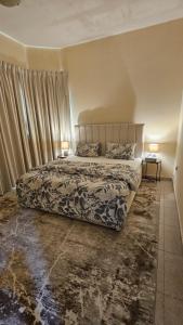 Un dormitorio con una cama y dos lámparas sobre dos mesas. en Splendid Private Rooms, en Sharjah
