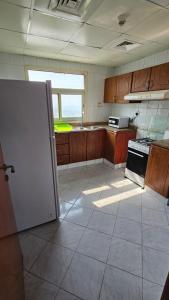Una cocina con un refrigerador blanco y una estufa. en Splendid Private Rooms, en Sharjah