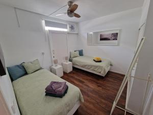 a room with two beds and a ceiling fan at Casa Playa Chica Lanzarote in Puerto del Carmen