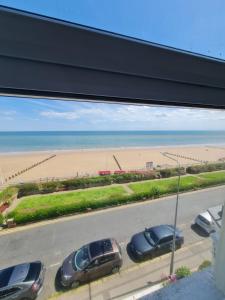 a view of a beach with cars parked in a parking lot at Farina No5, Sea view studio sleeping 2 guests in Bridlington +1 photo