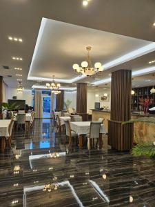 a dining room with tables and chairs and a chandelier at 4 Stinët in Valbonë