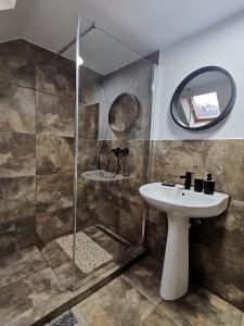 a bathroom with a sink and a shower at Shelby Accommodation -Adult Only- in Sinaia