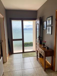 a room with a large door with a view of the ocean at Shamrock Cottage in Inch