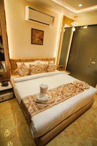 a bedroom with a large bed with a vase on it at Hotel Ammison Inn & Suites in Amritsar